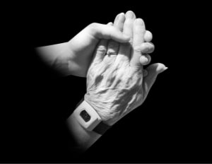 Black and white photo of two people holding hands